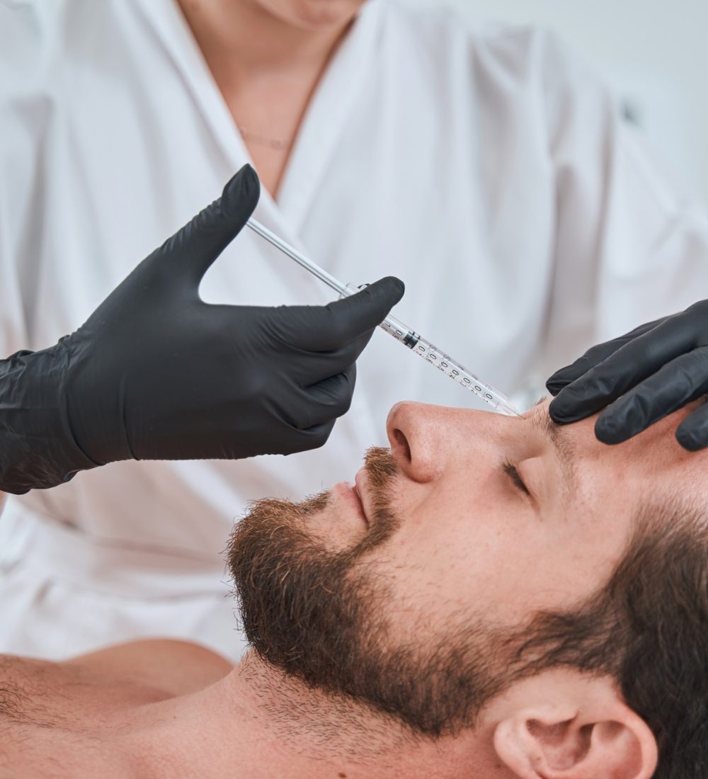 Man getting a dermal filler injection into the glabellar line